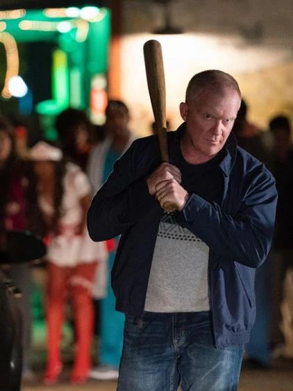 Man holding a baseball bat in a crowd at night