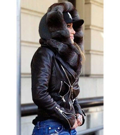 Person wearing a dark brown leather jacket with fur lining and a matching beanie outdoors.